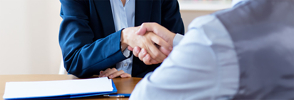 Aperto de mãos entre profissionais durante reunião para contratação de serviço de inventário patrimonial