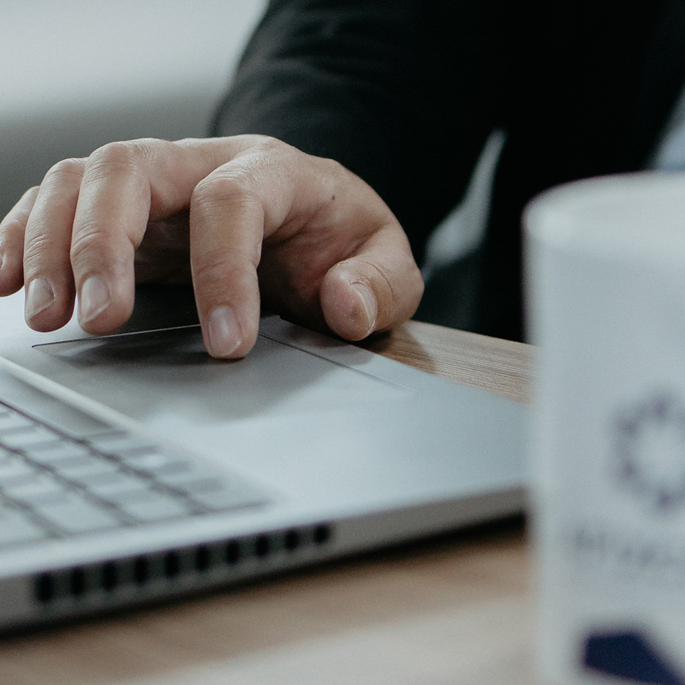 Profissional utilizando notebook para análise de dados no processo de avaliação de bens móveis em ambiente corporativo