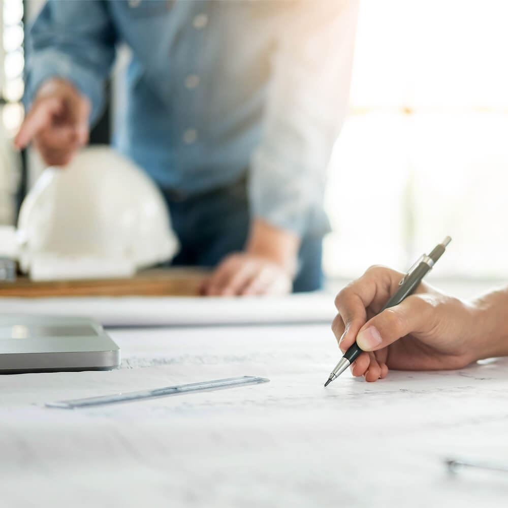 Profissional analisando plantas técnicas em mesa durante mensuração estratégica de ativos biológicos e planejamento técnico