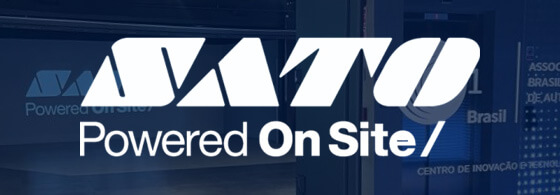 Logotipo SATO Powered On Site exibido em ambiente corporativo com identidade visual da marca